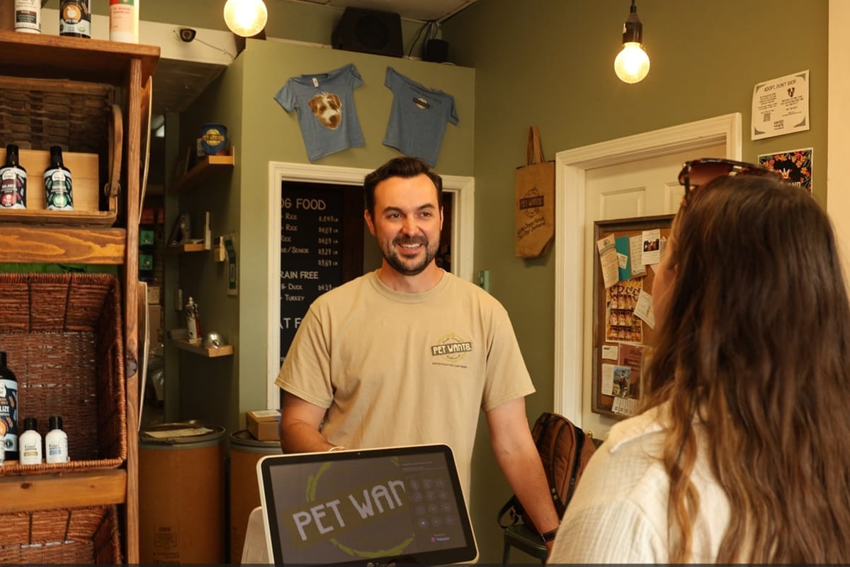 A Pet Wants owner helping a customer in the store